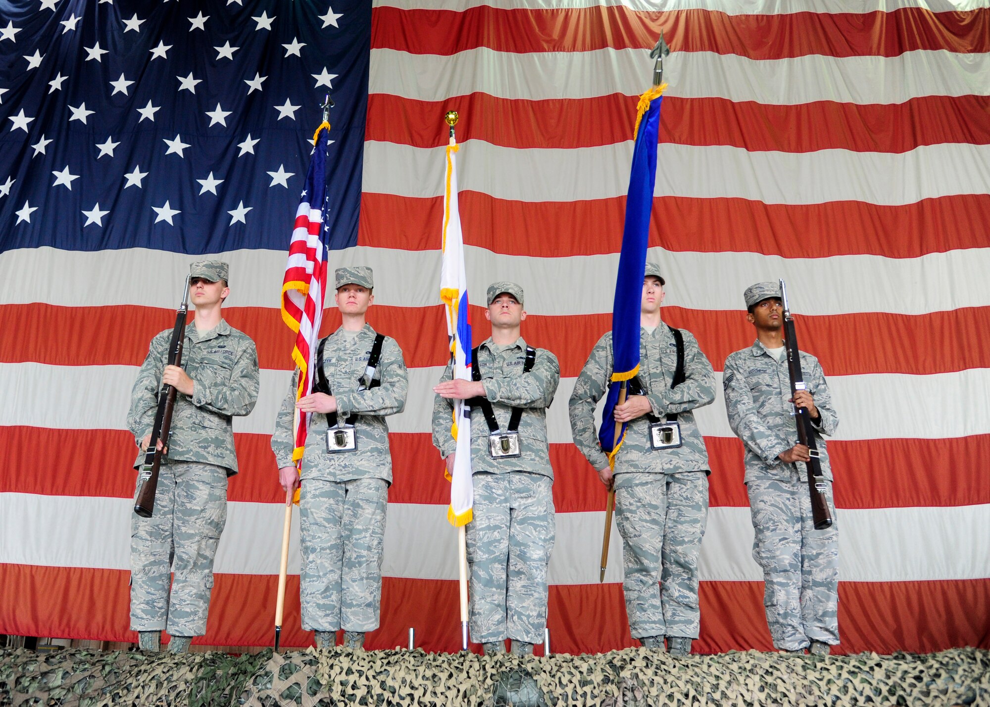 Airmen with the base honor guard present the colors during the 8th Maintenance Group change of command at Kunsan Air Base, Republic of Korea, June 5, 2014. The mission of the Kunsan AB Honor Guard is to represent every member, past and present, of the United States Air Force by performing color guard duties. (U.S. Air Force photo by Senior Airman Taylor Curry/Released)