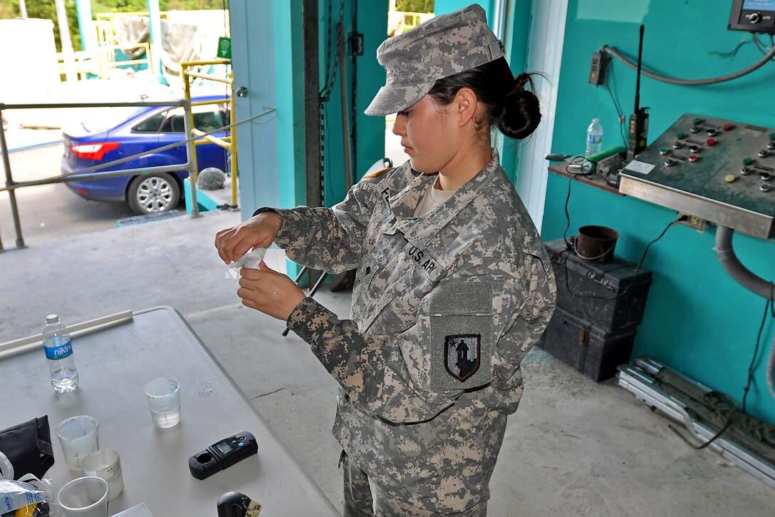 Army Spc. Pamela Pereira tests the water during training to purify water at the water utilities facility in San Lorenzo, Puerto Rico, May 31, 2014. Pereira is a water treatment specialist assigned to the Puerto Rico Army National Guard's 714th Quartermaster Company, 191st Regional Support Group.