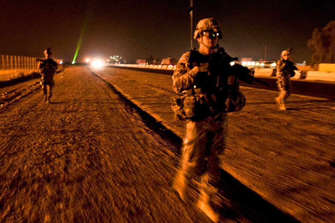 U.S. Army military policemen conduct a dismounted patrol along a road outside Camp Taji, Iraq, Dec. 2, 2011. The policemen are assigned to the 82nd Airborne Division's 2nd Brigade, Company H, 2nd Brigade Special Troops Battalion.  
