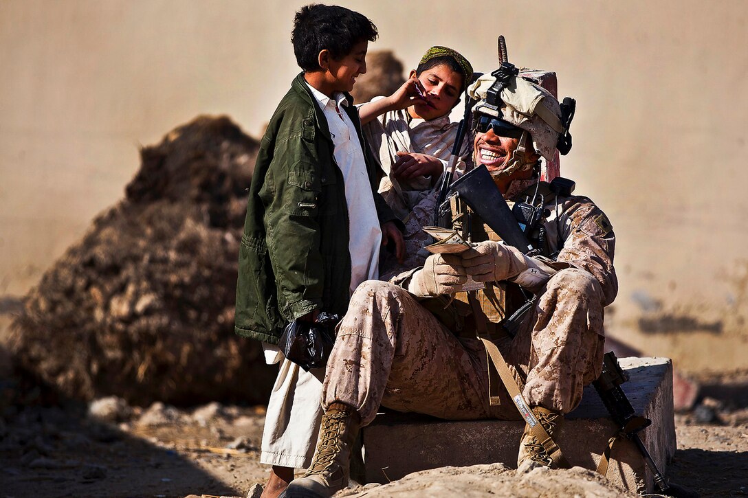 U.S. Marine Sgt. Marcus Martin practices Pashto with Afghan boys while providing security outside the district center in Garmser district, Helmand province, Nov. 28, 2011. Martin is a squad leader assigned to the 3rd Battalion, 3rd Marine Regiment. 
