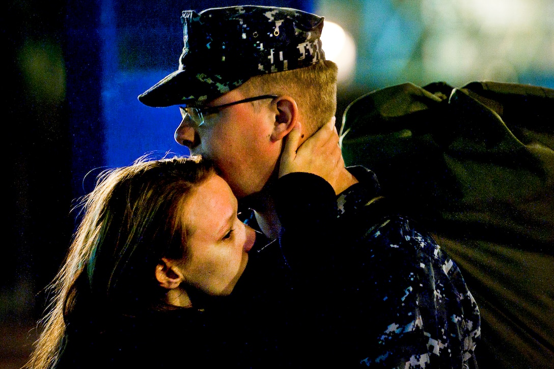 A sailor embraces a family member before the aircraft carrier USS Carl Vinson departs Naval Air Station North Island in Coronado, Calif., Nov. 30, 2011, for deployment to a western Pacific region.  
