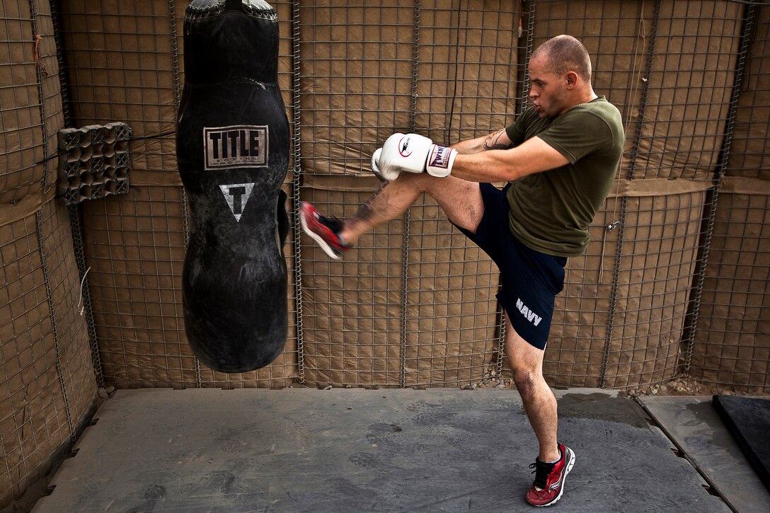 U.S. Navy Seaman Chris Mesnard practices kickboxing while training in mixed martial arts inside a makeshift combat-zone gym in the Garmsir District, Helmand Province, Afghanistan, Nov. 26, 2011. 
