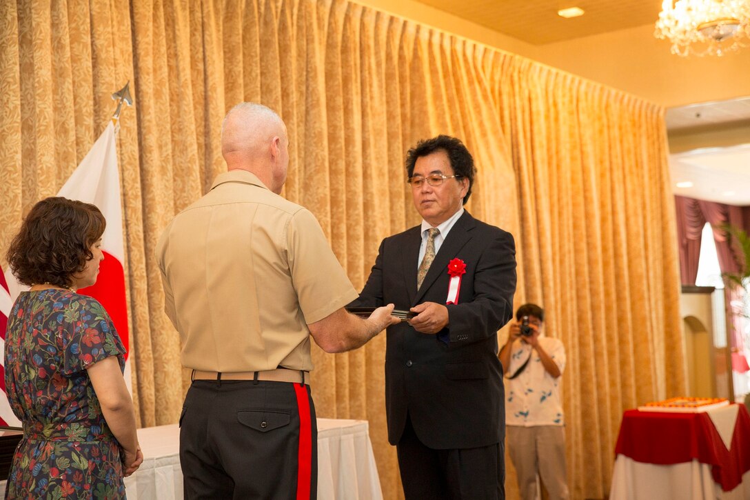 Masaharu Nakamura, right, receives a certificate of appreciation from Maj. Gen. Charles L. Hudson June 4 at the Butler Officers’ Club on Camp Foster. Nakamura is one of 18 retirees who were recognized for their many years of service to Marine Corps Installations Pacific and Marine Corps Base Camp Smedley D. Butler. Nakamura spent 23 years as a translator with the Provost Marshal’s Office North District, MCB Camp Butler, MCIPAC. Hudson is the commanding general of MCIPAC and MCB Camp Butler. (U.S. Marine Corps photo by Cpl. Adam B. Miller/Released)