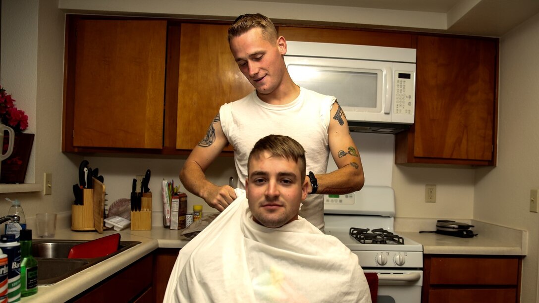 Corporal Carl Provost, automotive mechanic, 15th Marine Expeditionary Unit, prepares to shave Lance Cpl. Benjamin Mullenaux, floor mechanic, Combat Logistics Battalion 5, at his home aboard Camp Pendleton, Calif., June 8, 2014. Provost is from Duluth, Minn. (U.S. Marine Corps photo by Lance Cpl. Anna Albrecht/Released)