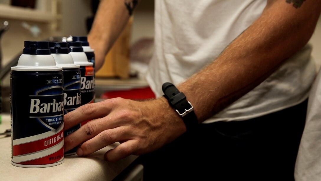 Corporal Carl Provost, automotive mechanic, 15th Marine Expeditionary Unit, chooses which shaving cream to use at his home aboard Camp Pendleton, Calif. June 8, 2014. Provost is from Duluth, Minn. (U.S. Marine Corps photo by Lance Cpl. Anna Albrecht/Released)