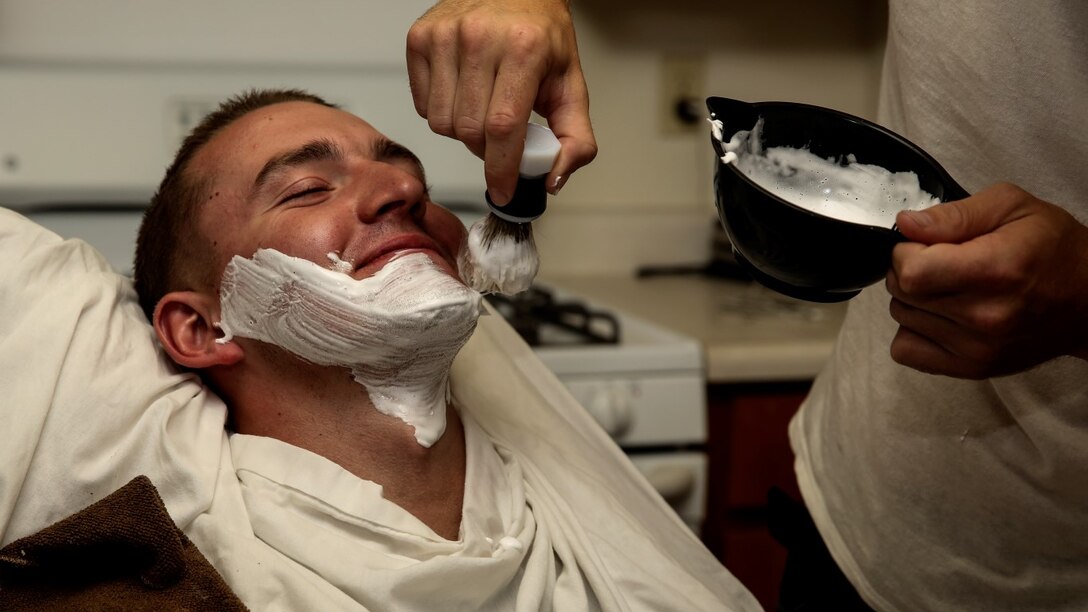 Corporal Carl Provost, automotive mechanic, 15th Marine Expeditionary Unit, brushes shaving cream on Lance Cpl. Lukasz Wlodkowski, automotive maintenance technician, Combat Logistics Battalion 5, at his home aboard Camp Pendleton, Calif. June 8, 2014. Provost is from Duluth, Minn. (U.S. Marine Corps photo by Lance Cpl. Anna Albrecht/Released)