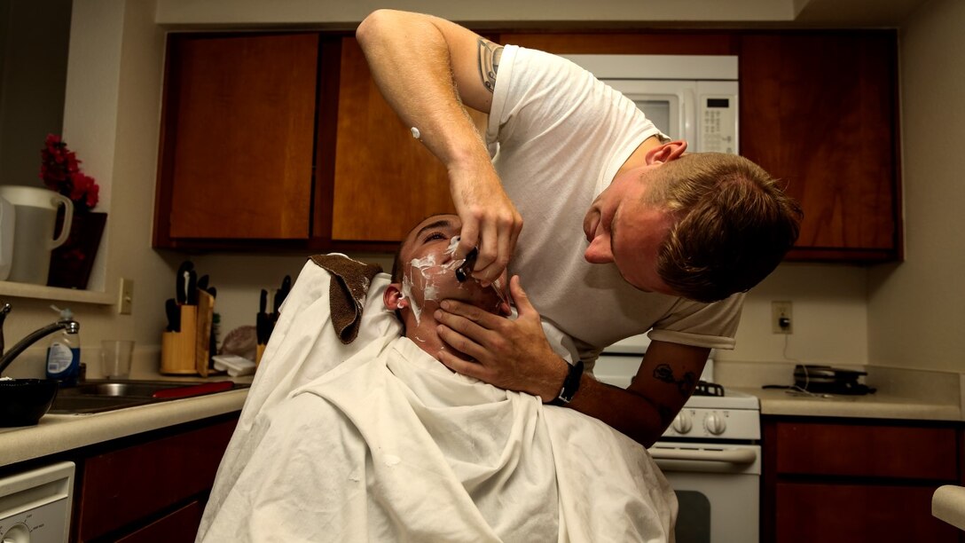 Corporal Carl Provost, automotive mechanic, 15th Marine Expeditionary Unit, shaves Lance Cpl. Lukasz Wlodkowski, automotive maintenance technician, Combat Logistics Battalion 5, at his home aboard Camp Pendleton, Calif. June 8, 2014. Provost is from Duluth, Minn. (U.S. Marine Corps photo by Lance Cpl. Anna Albrecht/Released)