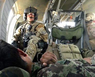 Army Sgt. Cliff Aughe, a flight medic with C Company, 1st Battalion, 171st Aviation Regiment, New Mexico Army National Guard, watches over a soldier from the Afghan National Army during an evacuation mission in Afghanistan March 27, 2012. 