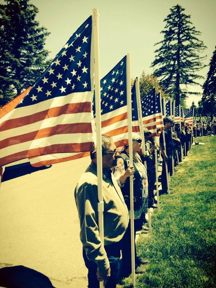 Friends and family of Pfc. Chester Nez, the last original Navajo Code Talker, surround his grave with American Flags at the Santa Fe National Cemetery, June 10.