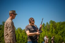 A civilian Marine who works in the Program and Resources Office at Headquarters Marine Corps learns about different small arms before doing live at Weapons Training Battalion. Employees from P&R visited Quantico June 6, to better understand how their work impacts Marines in the fleet. 