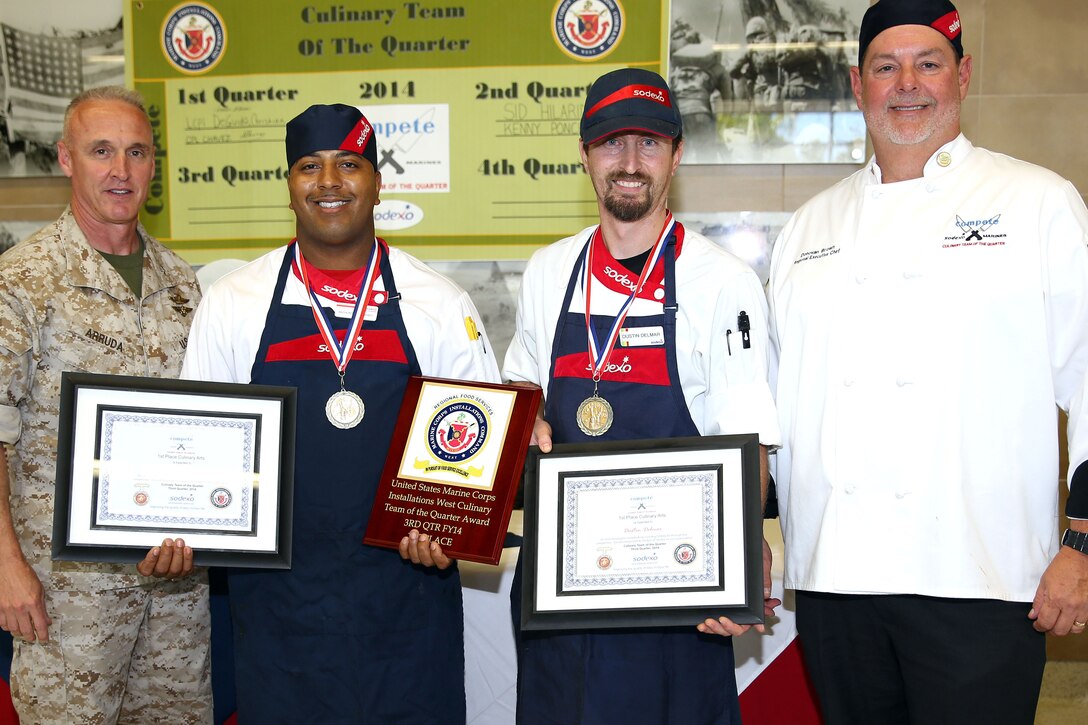 CAMP PENDLETON, Calif. - Three teams of two competed for the title of the Culinary Team of the Quarter at the 31 Area Mess Hall on Edson Range here June 11. The winners for this quarter were Team 1, Dustin Delmar and Anthony Stewart who work at the 33 Area Mess Hall here.

The competition is a two-day event.  On the first day, 12 teams competed in a book test and a Jeopardy-style quiz. Only four teams qualified to move on to the cooking portion of the competition the following day.

The theme of the cooking competition this quarter was barbeque and each team was expected to make a protein dish using chicken or pork, cornbread and a salad. This quarter the competition included 45 minutes of assistance to each team from guest chef Rahm Fama.

This competition is used not only as an training tool, but also to build camaraderie among the food service community, said Donovan Brown, the Marine Corps Installations West Regional executive chef.

From Left to Right: Col. Jeff Arruda, Anthony Stewart, Dustin Delmar, Donovan Brown.