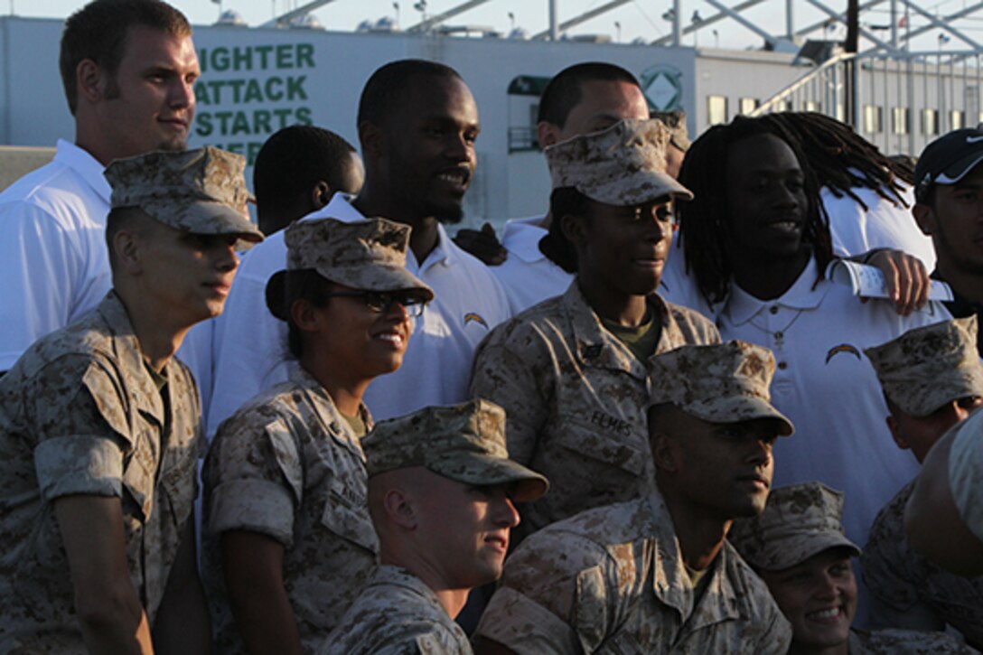 Marines pose for a photo with members of the San Diego Chargers following an evening colors ceremony aboard Marine Corps Air Station Miramar, Calif., June 10. The ceremony recognized the San Diego Chargers for their service to military members in surrounding communities. The event featured 3rd Marine Aircraft Wing and MCAS Miramar noncommissioned officers as part of the Committed and Engaged Leadership initiative, originated by Maj. Gen. Steven Busby, 3rd MAW commanding general.