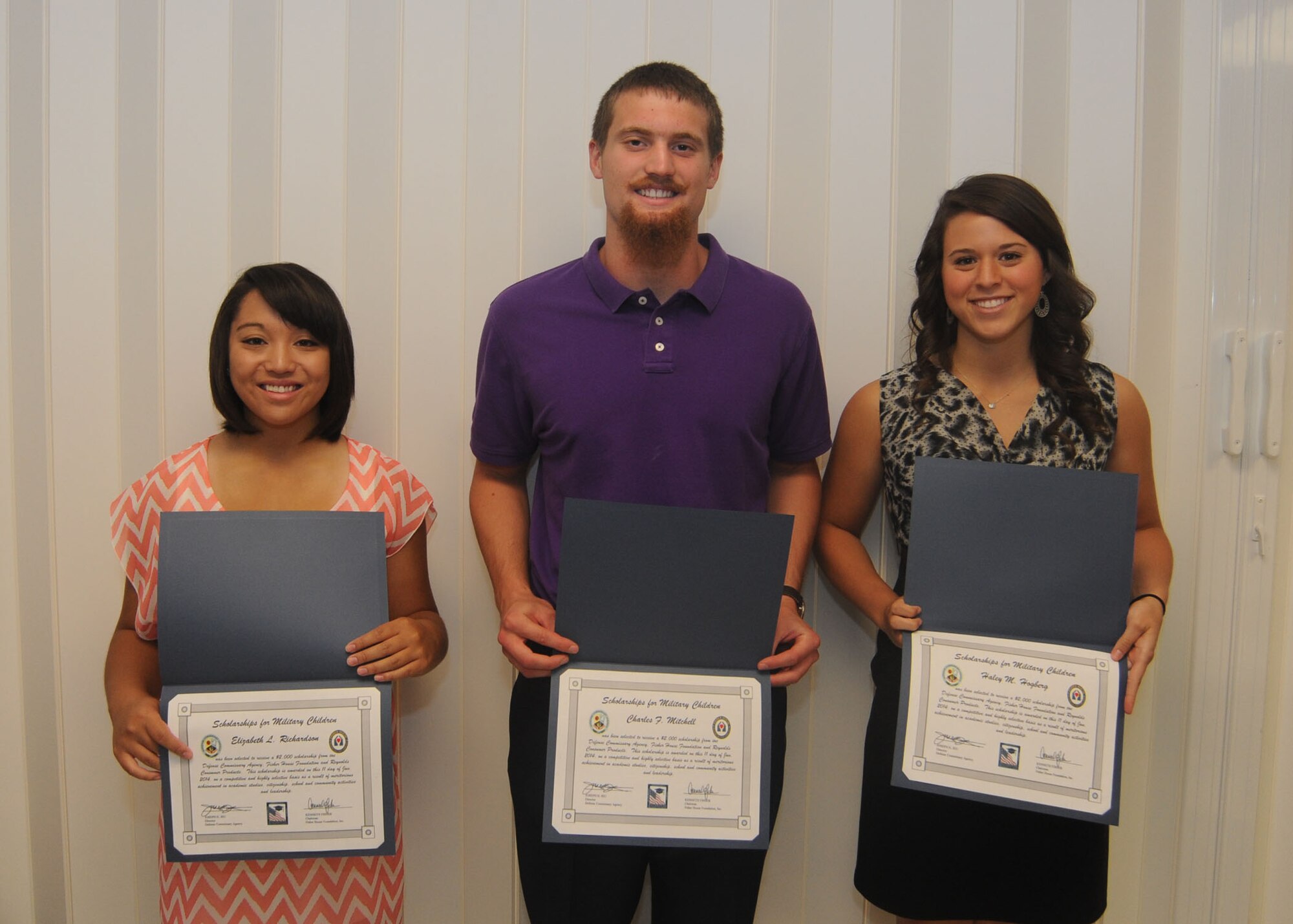 Elizabeth Richardson, Charles Mitchell and Haley Hogberg hold their award certificates for winning the Fairchild edition of Scholarships for Military Children at Fairchild Air Force Base, Wash., June 11, 2014. The Fisher House-sponsored award is a $2,000 scholarship for graduating high school seniors and students currently enrolled in a four-year program. A minimum 3.0 grade point average and demonstration of community involvement are among the requirements for consideration. (U.S. Air Force photo by Airman 1st Class Sam Fogleman/Released)