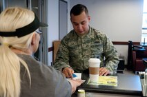 Airman Marvin Dominguez, 790th Missile Security Forces Squadron, receives a free coffee from the First Sergeant’s Counsel June 10, 2014, in the Fall Hall Starbucks. The counsel divided $300 around several food and beverage vendors on base so Airmen could get a free drink or meal. (U.S. Air Force photo by Airman Malcolm Mayfield)