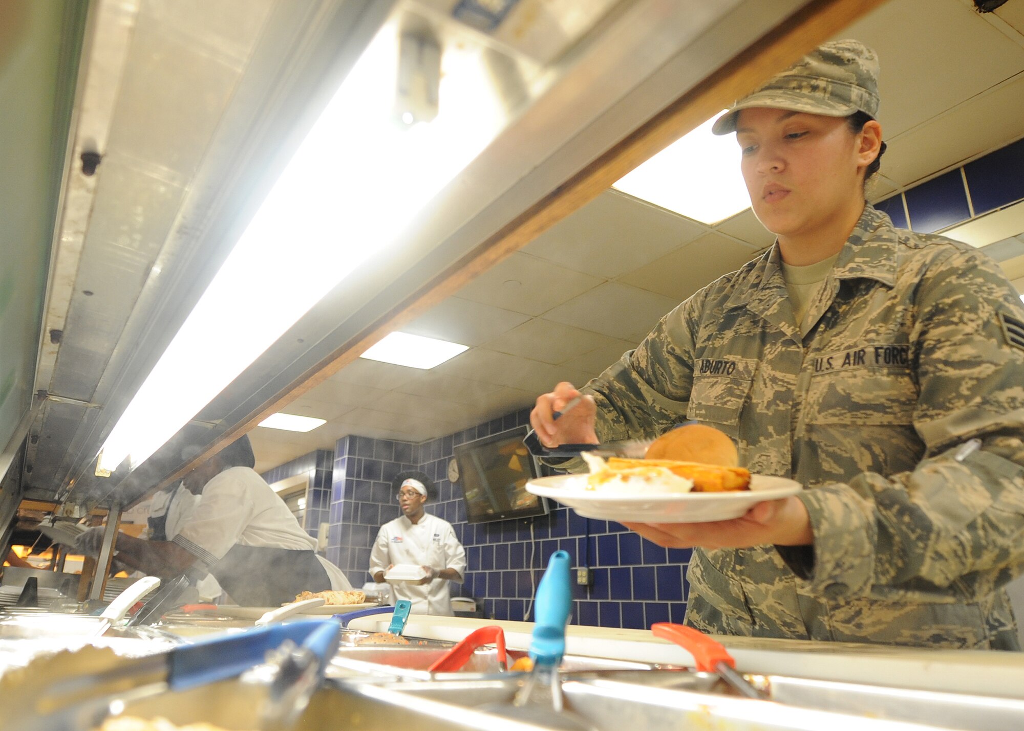 ALTUS AIR FORCE BASE, Okla. – U.S. Air Force Senior Airman Erika Aburto, 97th Force Support Squadron food service technician, prepares a plate of food at the Solar Inn Dining Facility June 6, 2014. The dining facility is an essential part of the Altus AFB mission, replenishing Airmen with four meals a day to keep the mission going of forging combat mobility forces and deploying Airmen warriors.   (U.S. Air Force photo by Senior Airman Levin Boland/Released) 