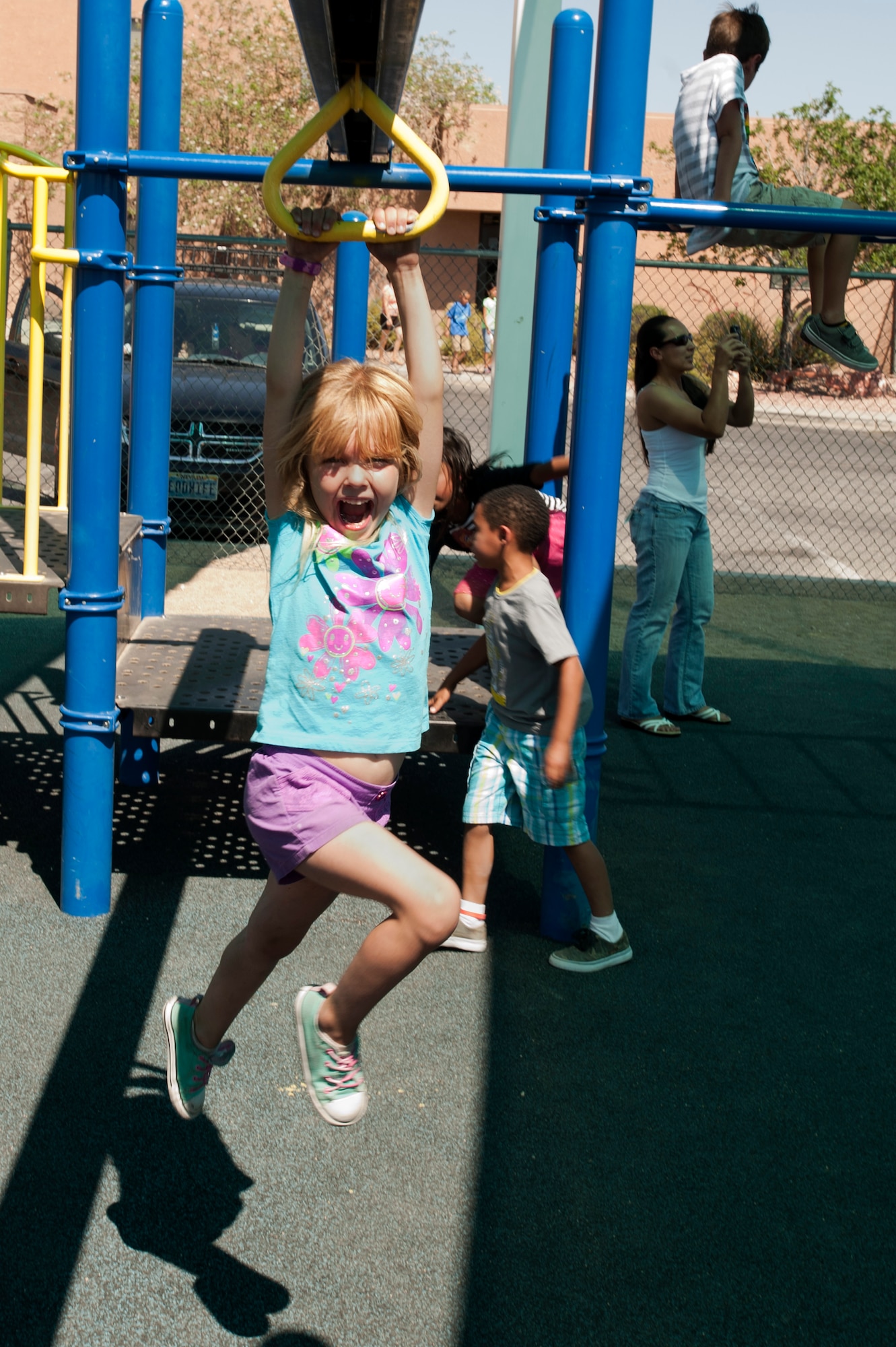 Lillian swings across a playground zip line on the playground of the 99th Force Support Squadron Youth Center June 5, 2014, at Nellis Air Force Base, Nev. The youth center staff has a large increase of members during the summer months. (U.S. Air Force photo by Senior Airman Timothy Young)