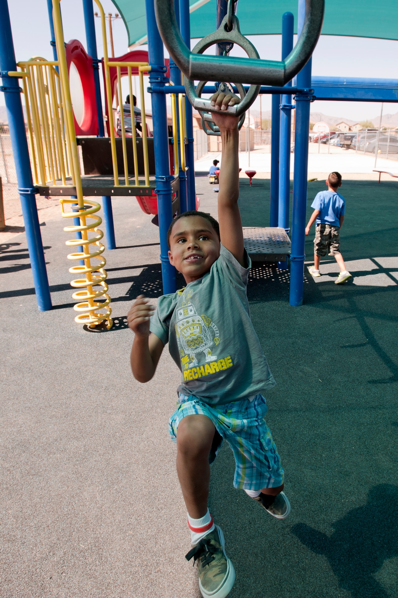 LaVan swings across monkey rings outside the 99th Force Support Squadron Youth Center June 5, 2014, at Nellis Air Force Base, Nev. Children ages 6 to 12 are eligible for full day child care at the youth center and children ages 9 to 13 may participate in the leisure program. (U.S. Air Force photo by Senior Airman Timothy Young)