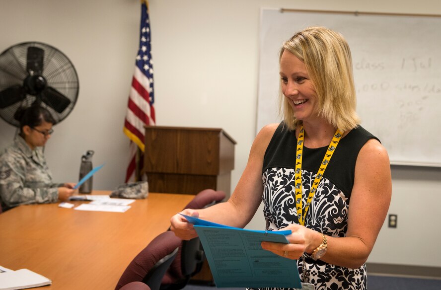 Erin Locke, 23d Medical Group health promotion dietician, passes out information sheets during a weight management class at Moody Air Force Base, Ga., June 2, 2014. Locke says the biggest problems people have with eating healthy is not eating frequently enough and portion sizes that are too large. (U.S. Air Force photo by Senior Airman Jarrod Grammel/Released)
