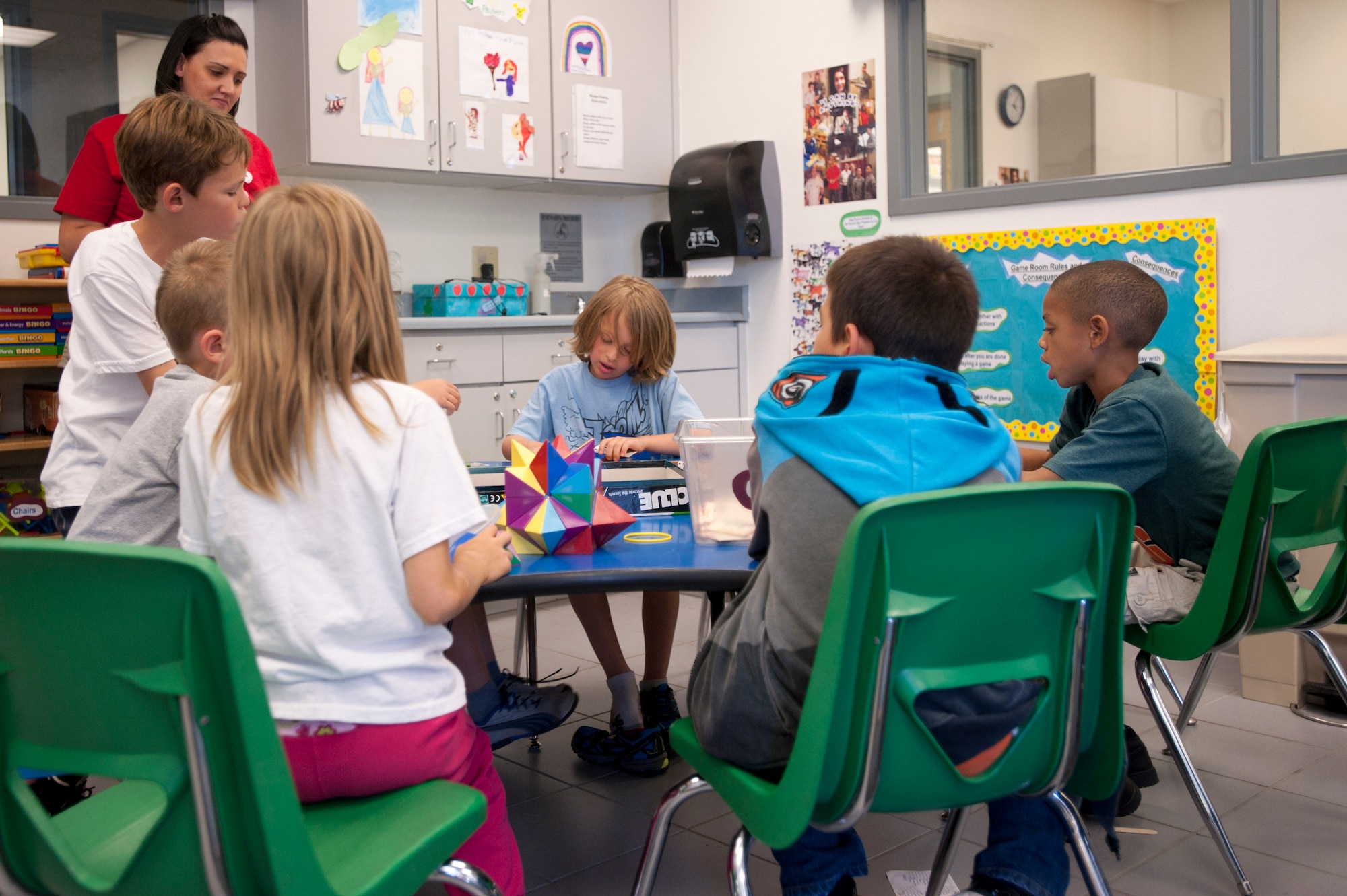 Children play a board game at the 99th Force Support Squadron Youth Center June 5, 2014, at Nellis Air Force Base, Nev. Children ages 6 to 12 are eligible for full day child care at the youth center. (U.S. Air Force photo by Senior Airman Timothy Young)