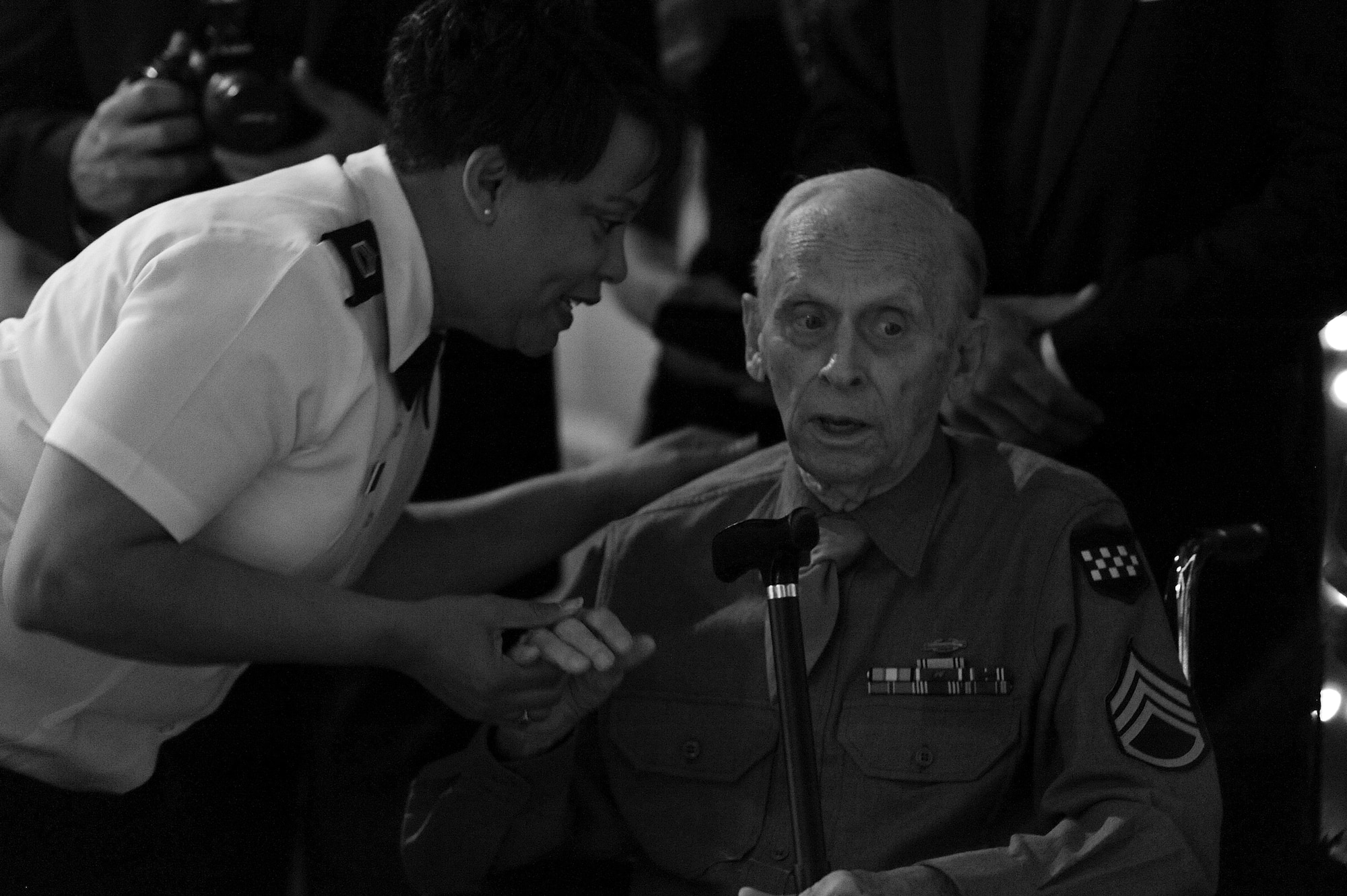 SAN ANGELO, Texas – Army Sgt. 1st Class Robyn E. Moore, 344th Military Intelligence Battalion personnel service NCO in charge, assists Bob Waldrep, D-Day Veteran, during the Army Ball at Fort Concho Stables here June 6. D-Day took place exactly 70 years ago when 160,000 allied troops landed along a 50-mile stretch of heavily-fortified French coastline to fight Nazi Germany on the beaches of Normandy. (U.S. Air Force photo/ Airman 1st Class Devin Boyer)