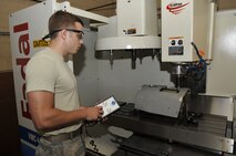 Senior Airman David Reid, 2nd Maintenance Squadron Aircraft Metals Technology journeyman, uses a computer numeric control machine to cut a hole in a cruise missile cowling on Barksdale Air Force Base, La., June 10, 2014. For some aircraft parts, dimensions of metal pieces and holes that are cut must be measured to within a thousandth of an inch. (U.S. Air Force photo/Airman 1st Class Benjamin Raughton)