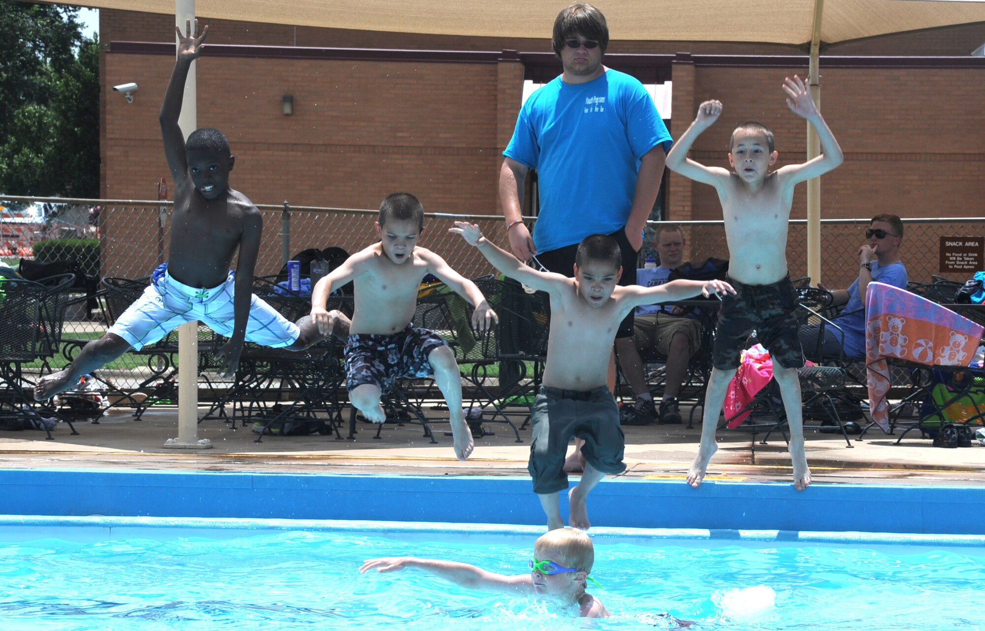 Boys attending Camp Tomahawk jump into the Plains Pool at Vance Air Force Base, Okla. Camp Tomahawk is a free summer camp for children in the local area. Donations to support the camp’s activities come from local businesses acquired by the Enid Chamber of Commerce. This is the 40th year Vance has hosted the camp and supplied volunteers to act as camp counselors for the children. (U.S. Air Force photo/Senior Airman Frank Casciotta)
