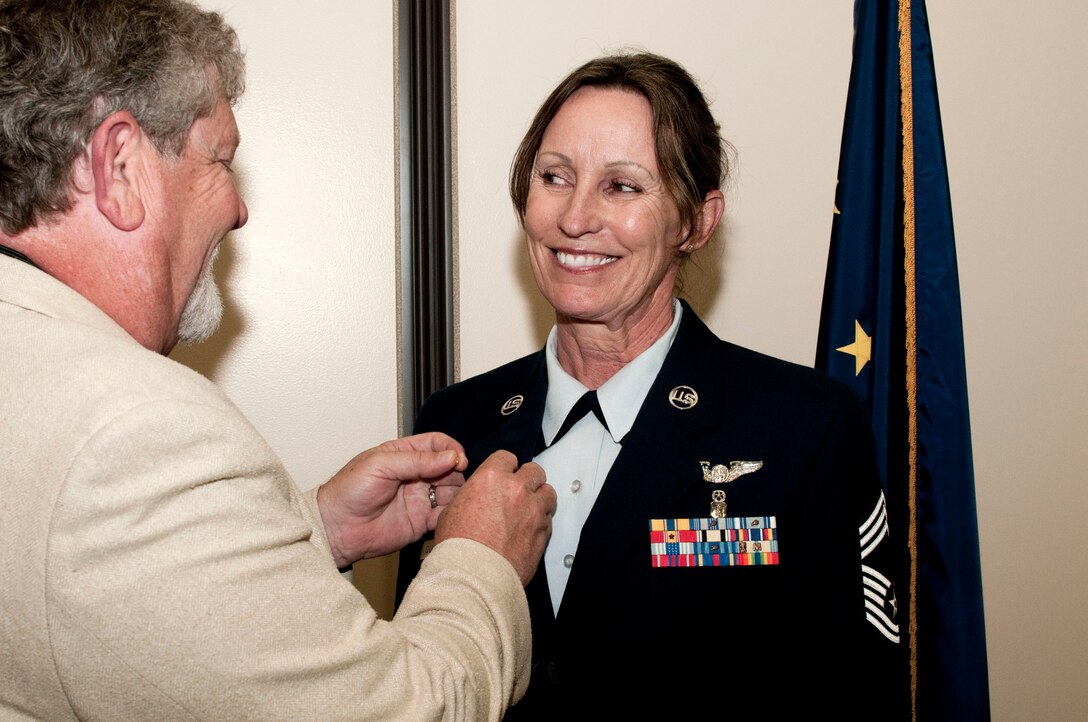 JOINT BASE ELMENDORF-RICHARDSON, Alaska -- Chief Master Sgt. Jacquelyn Quattlebaum, superintendent of the 176th Medical Group, receives her retirement pin from her fiancé here June 10, 2014.  Quattlebaum began her career in 1992 as an Army National Guard dental technician. Today she was recognized for her 22 years of military service. (U.S. Air National Guard photo by Tech. Sgt. Jennifer Theulen/ Released)