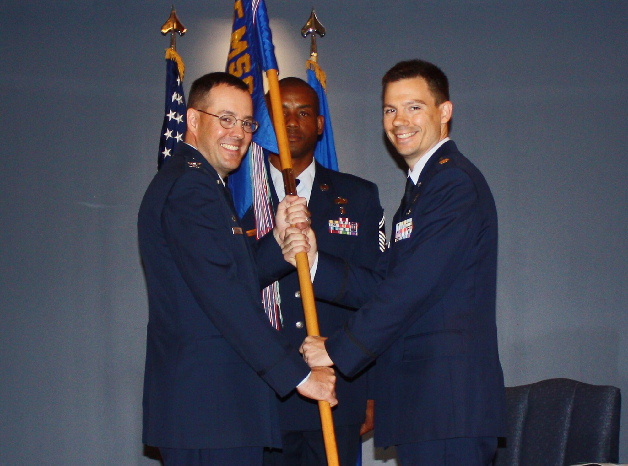 Col. Christopher Holmes, the 325th Mission Support Group commander, passes the 325th Contracting Squadron guidon to Maj. Bryan Lamb, 325th CONS commander, during a change of command ceremony June 6. Lamb replaces Lt. Col. Antonio Gonzalez who will be headed to the Pentagon, District of Columbia, as the Defense Department Inspector General program acquisition evaluator. (U.S. Air Force courtesy photo)