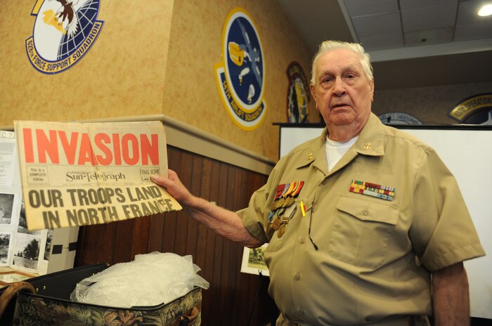 Retired Navy Chief Petty Officer Arlington Sandford, holds a newspaper from 1941 at the start of World War II during a visit on June 6, 2014, in honor of the 70th Anniversary of D-Day at Joint Base Charleston, S.C. Sandford served during D-Day.  (U.S. Air Force photo/ Staff Sgt. William A. O’Brien)