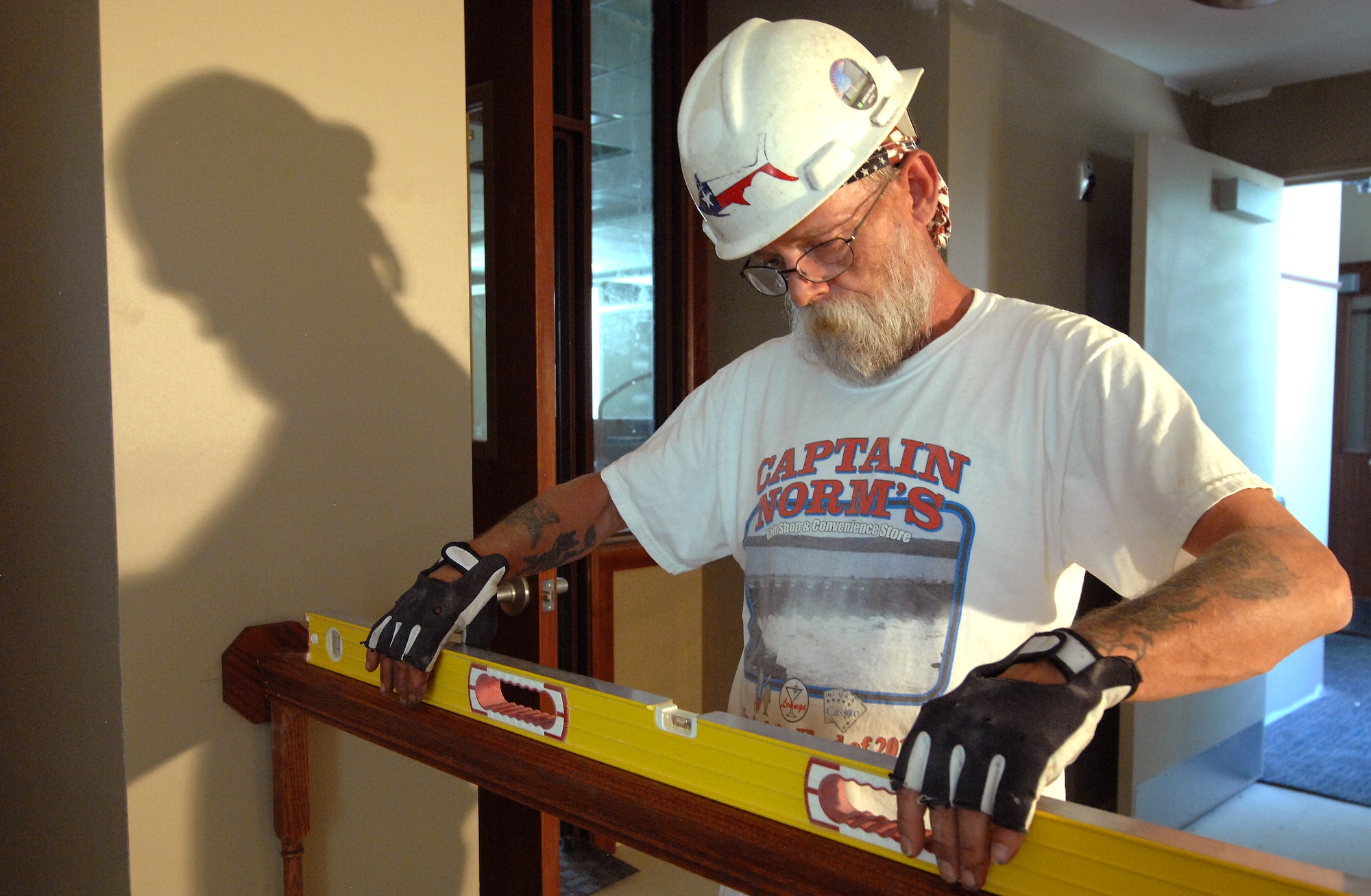 Jim Beggs, a contracted carpenter from South Sioux City, Iowa, levels a hand rail while completing finish work inside Building 49. The building, which was built in 1894, is receiving $5 million in renovations that are scheduled for completion later this summer. The updates will provide 32,000 square feet of office space for the 55th Mission Support Group and 55th Force Support Squadron. (U.S. Air Force photo/Delanie Stafford)