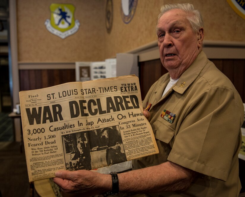 Retired Navy Chief Petty Officer Arlington Sandford, holds a newspaper from 1941 at the start of World War II during a visit on June 6, 2014, in honor of the 70th Anniversary of D-Day at Joint Base Charleston, S.C. Sandford served during D-Day. (U.S. Air Force photo/ Senior Airman Dennis Sloan)
