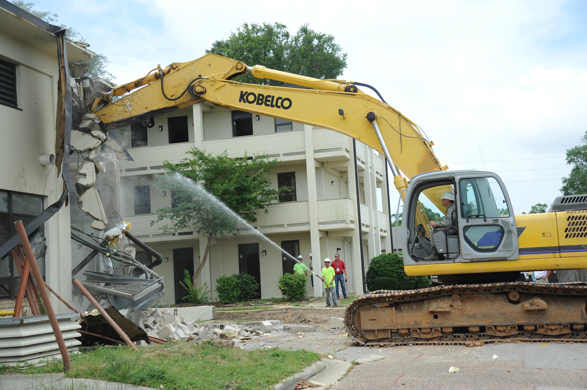Brig. Gen. Patrick Higby, 81st Training Wing commander, operates an excavator to begin the demolishing of building 4815 June 10, 2014, at Keesler Air Force Base, Miss.  The demolishing of Building 4815 will be continued by Business Integrity Commission, the prime demolishing contractor. (U.S. Air Force photo by Kemberly Groue)