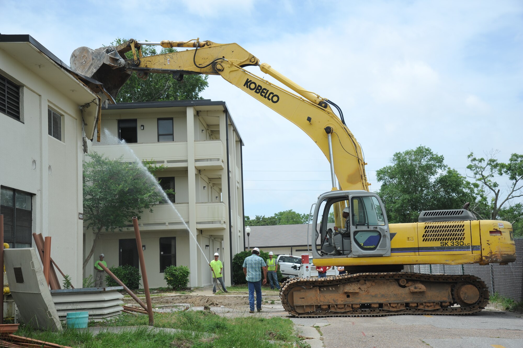 Chief Master Sgt. Farrell Thomas, 81st Training Wing command chief, operates an excavator to begin the demolishing of building 4815 June 10, 2014, at Keesler Air Force Base, Miss.  The demolishing of Buildings 4815 and 4813 will be continued by Business Integrity Commission, the prime demolishing contractor. (U.S. Air Force photo by Kemberly Groue)