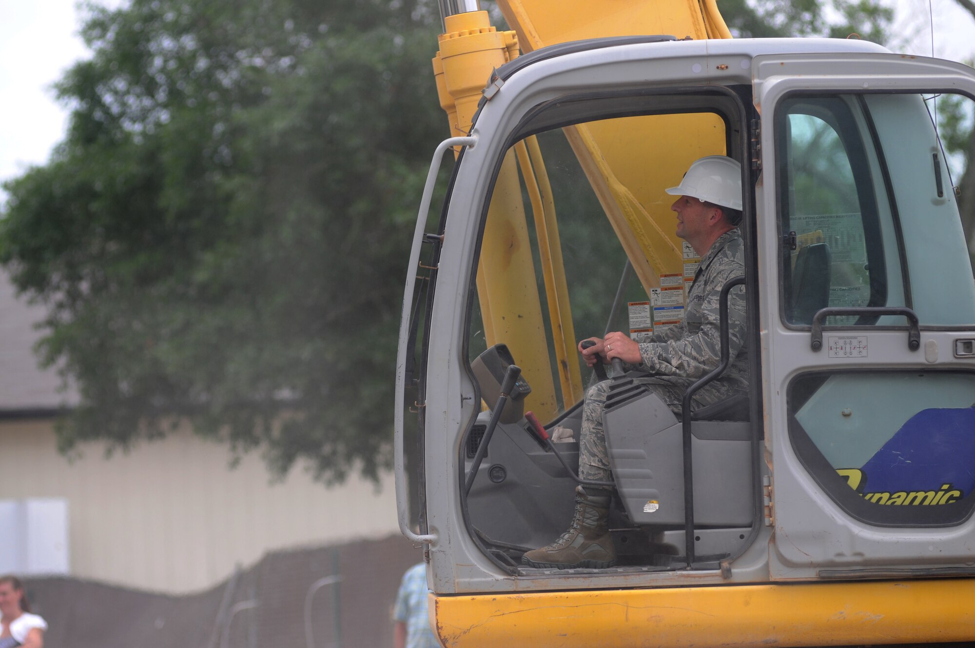 Brig. Gen. Patrick Higby, 81st Training Wing commander, operates an excavator to begin the demolishing of building 4815 June 10, 2014, at Keesler Air Force Base, Miss.  The demolishing of Building 4815 will be continued by Business Integrity Commission, the prime demolishing contractor. (U.S. Air Force photo by Kemberly Groue)
