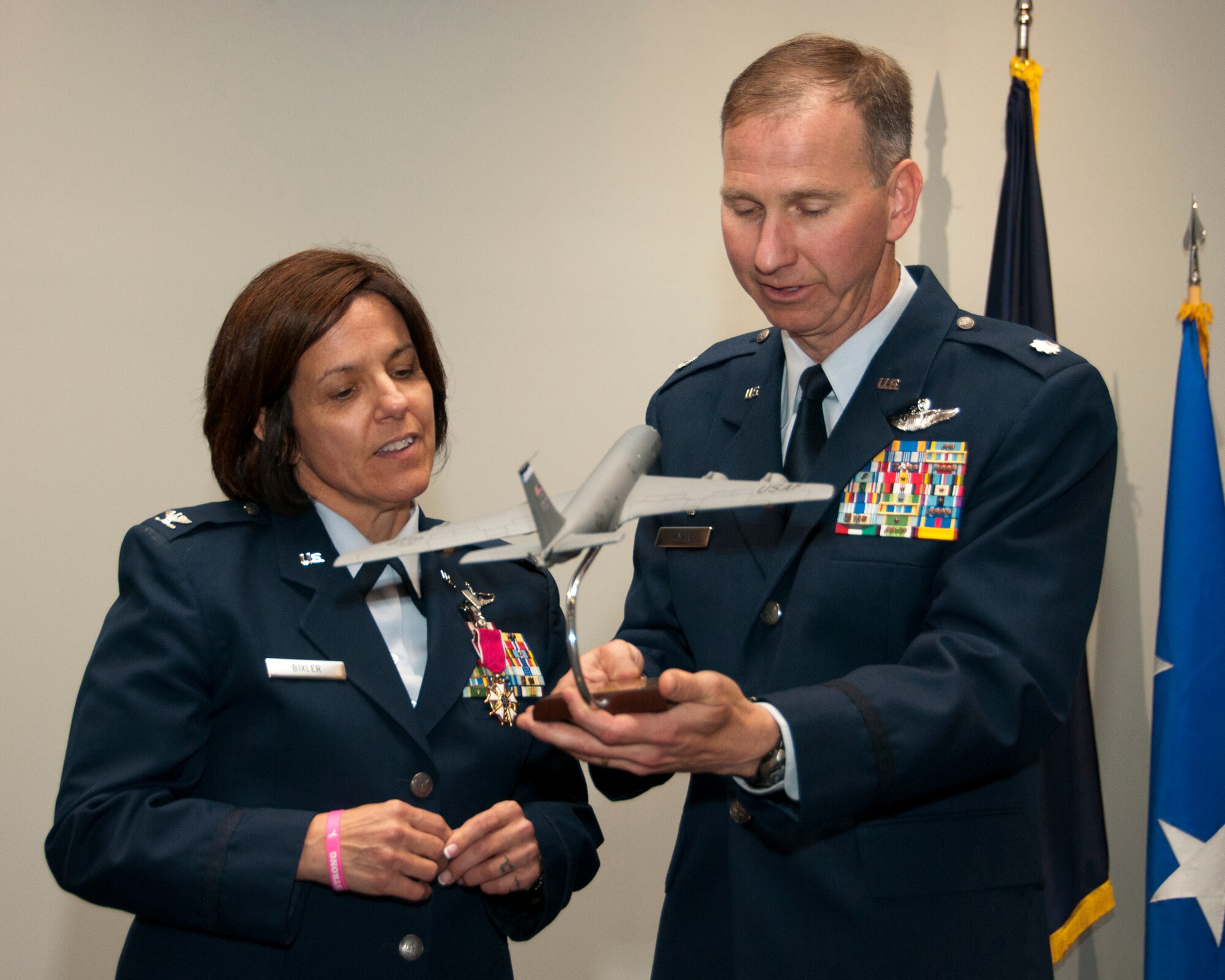 PEASE AIR NATIONAL GUARD BASE, N.H—Lt. Col. Jim Ryan presents Col. Nicole L. Desilets-Bixler  with a model KC-135 Stratotanker during her  during her retirement ceremony in building 264, on June 8, 2014. Bixler retires after 34 years of service and she has the distinction of being on the first N.H. Guard all-female flight crew which flew veterans to the Woman's memorial in Washington D.C. for its dedication. (U.S. Air National Guard photo by Staff Sgt. Curtis J. Lenz) 