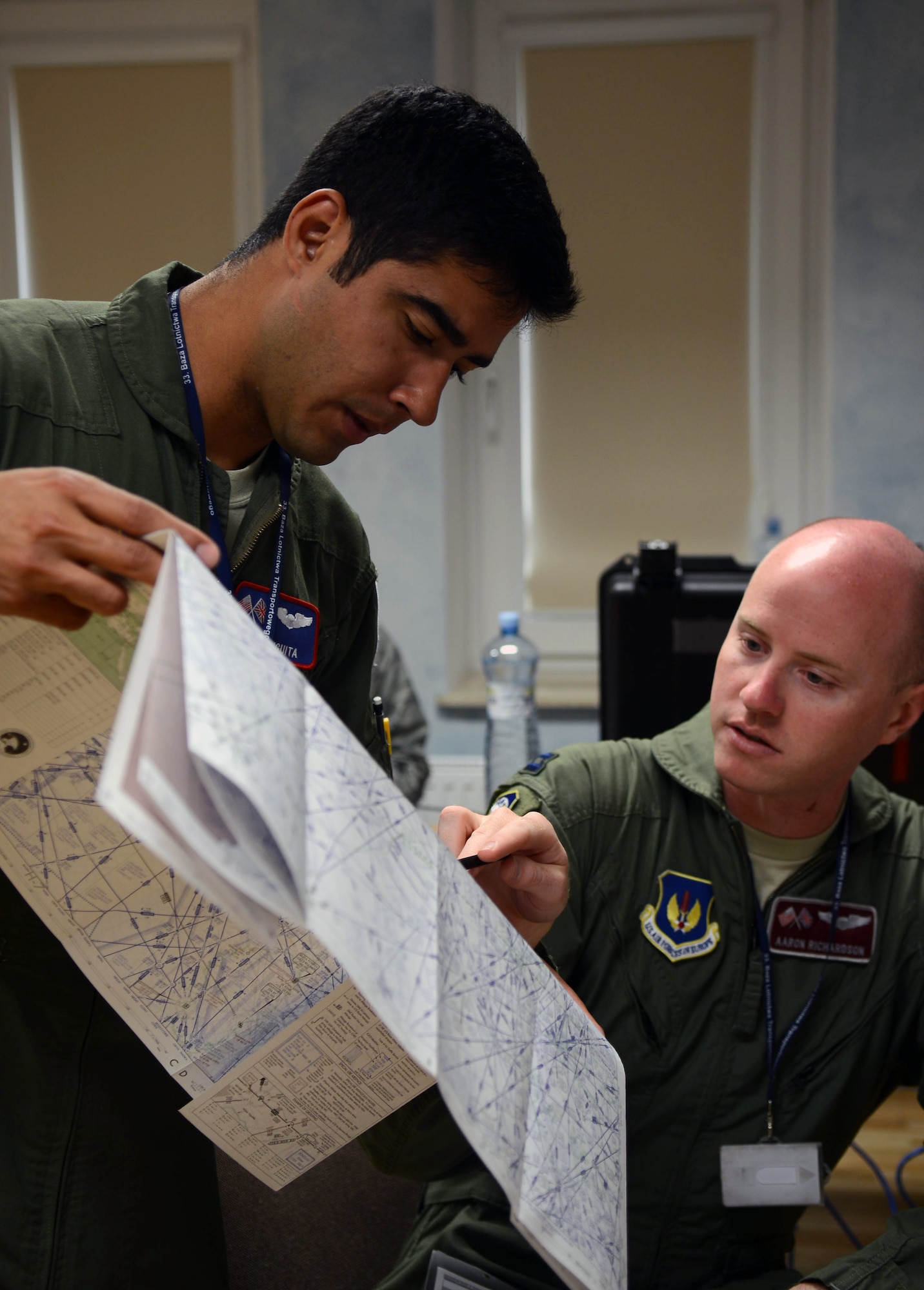 U.S. Air Force 1st Lt. Paul Anguita, left, 351st Expeditionary Air Refueling Squadron-Poland pilot from Mascoutah, Ill., and U.S. Air Force Capt. Aaron Richardson, 351st EARS-Poland pilot from Arvada, Colo., mission plan before a flight June 10, 2014, on Powidz Air Base, Poland, as part of the Baltic Operations Exercise. This exercise provides the opportunity for personnel of participating nations to engage in realistic training to build experience, teamwork and strengthen interoperability while working toward mutual goals. (U.S. Air Force photo/Airman 1st Class Kyla Gifford/Released)
