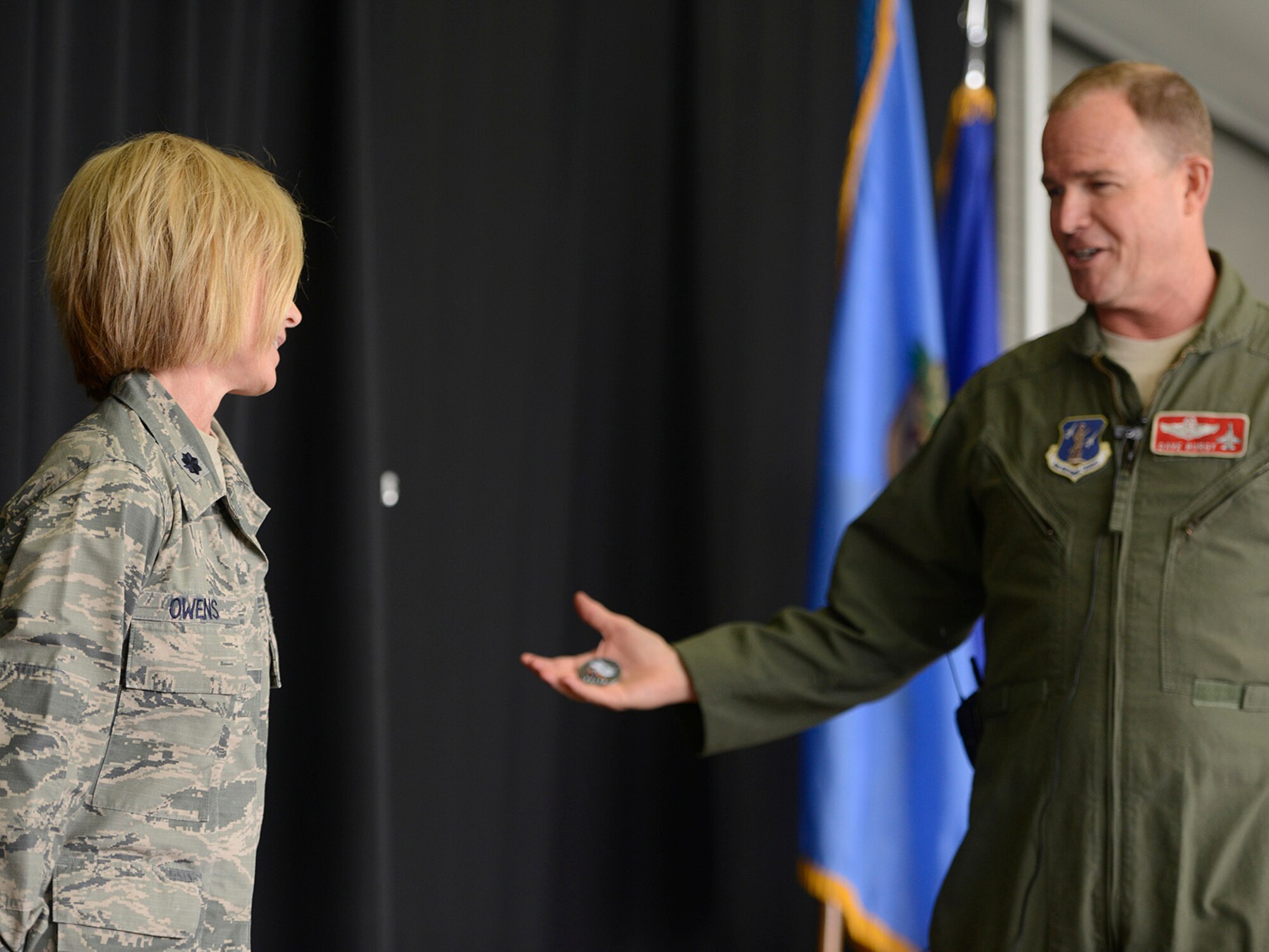Colonel David B. Burgy, 138th Fighter Wing Commander, presents the 138th FW Coin of Excellence to Lieutenant Colonel Deborah Owens, 138th Medical Squadron, for her efforts in the organization and execution of conducting Physical Health Assessments for a large portion of the base population.  The presentation was made during a Commanders Call at the Tulsa Air National Guard base, June 8, 2014.  (U.S. National Guard photo by Master Sgt.  Mark A. Moore/Released)