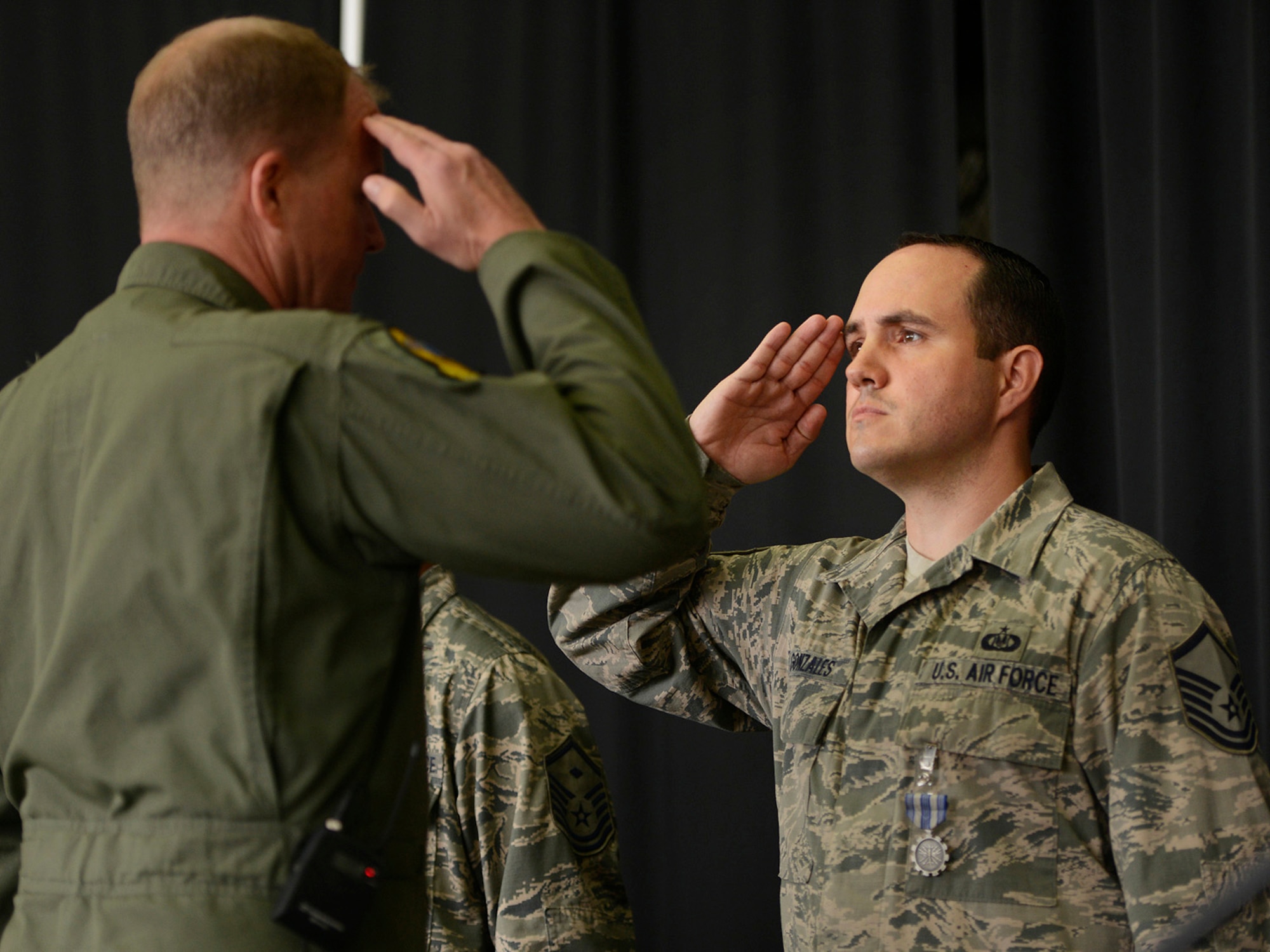 Colonel David B. Burgy, 138th Fighter Wing Commander, presents the U.S. Air Force Achievement Medal to Master Sergeant Timothy Gonzales for his outstanding work as a Family Assistance Officer.  The medal was presented during a Commanders Call at the Tulsa Air National Guard base, June 8, 2014.    (U.S. National Guard photo by Master Sgt.  Mark A. Moore/Released)