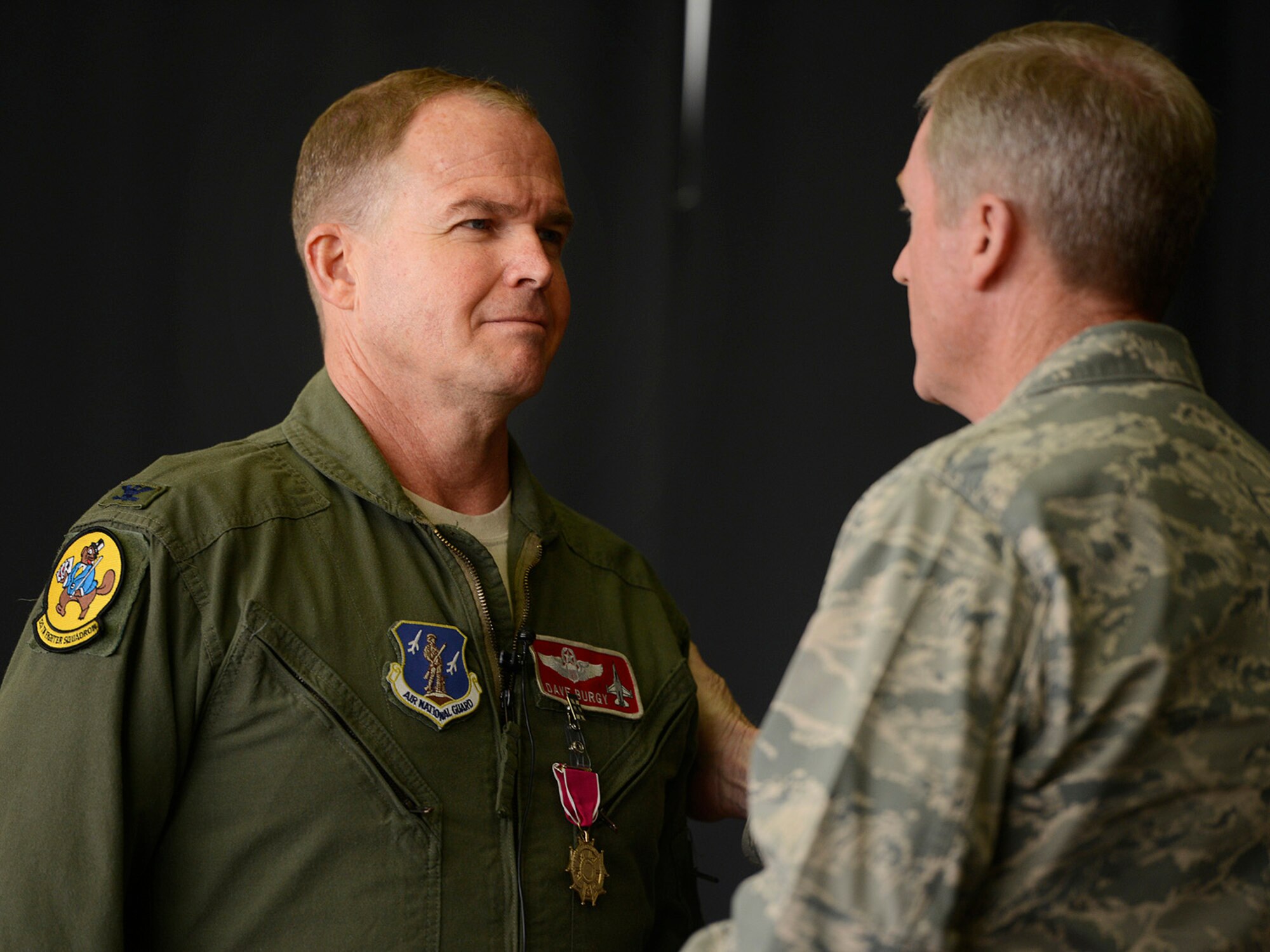 Colonel David B. Burgy, 138th Fighter Wing Commander, receives congratulations from Brigadier General Greg Ferguson, Assistant Adjutant General Air, after receiving the Legion of Merit medal during a Commanders Call at the Tulsa Air National Guard base, June 8, 2014.     (U.S. National Guard photo by Master Sgt.  Mark A. Moore/Released)