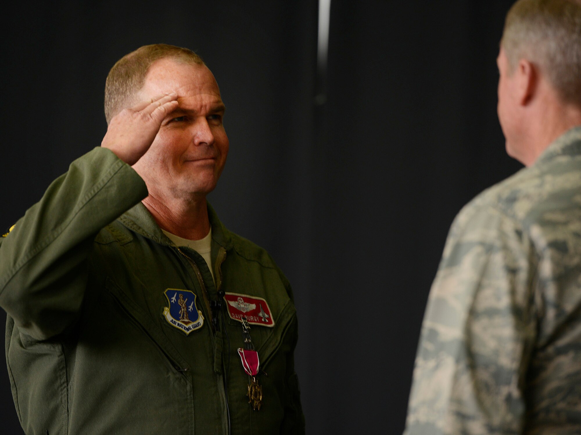 Colonel David B. Burgy, 138th Fighter Wing Commander, salutes Brigadier General Greg Ferguson, Assistant Adjutant General Air, after receiving the Legion of Merit medal during a Commanders Call at the Tulsa Air National Guard base, June 8, 2014.     (U.S. National Guard photo by Master Sgt.  Mark A. Moore/Released)