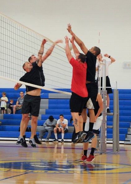 Ryan Mozingo and Nicholas Kolesnikov, 436th Operations Group, tip the ball past two 436th Aircraft Maintenance Squadron defenders during an intramural championship volleyball game June 6, 2014, at the fitness center on Dover Air Force Base, Del. The two teams went five rounds before the 436th OG came out victorious in the end. (U.S. Air Force photo/Senior Airman Jared Duhon)  