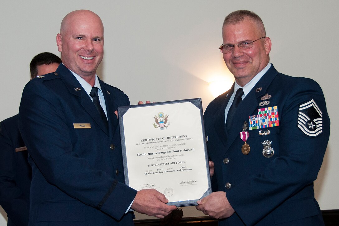 U.S. Air Force Capt. Jimmie Mills III, 94th Security Forces Squadron flight commander, presents the Certificate of Retirement to Senior Master Sgt. Paul Jarisch during a retirement ceremony on June 7, 2014, Barksdale Air Force Base, La. Jarisch is retiring from the Air Force Reserve after serving more than 33 years in the military. (U.S. Air Force photo by Tech. Sgt. Ted Daigle/Released)