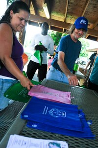 Joint Base Langley-Eustis volunteers grab gift bags as a reward for participating in Clean the Bay Day at Langley Air Force Base, Va., June 7, 2014. Almost 17 million people live around the Chesapeake Bay, which is the largest estuary in North America. (U.S. Air Force photo by Senior Airman Austin Harvill/Released) 