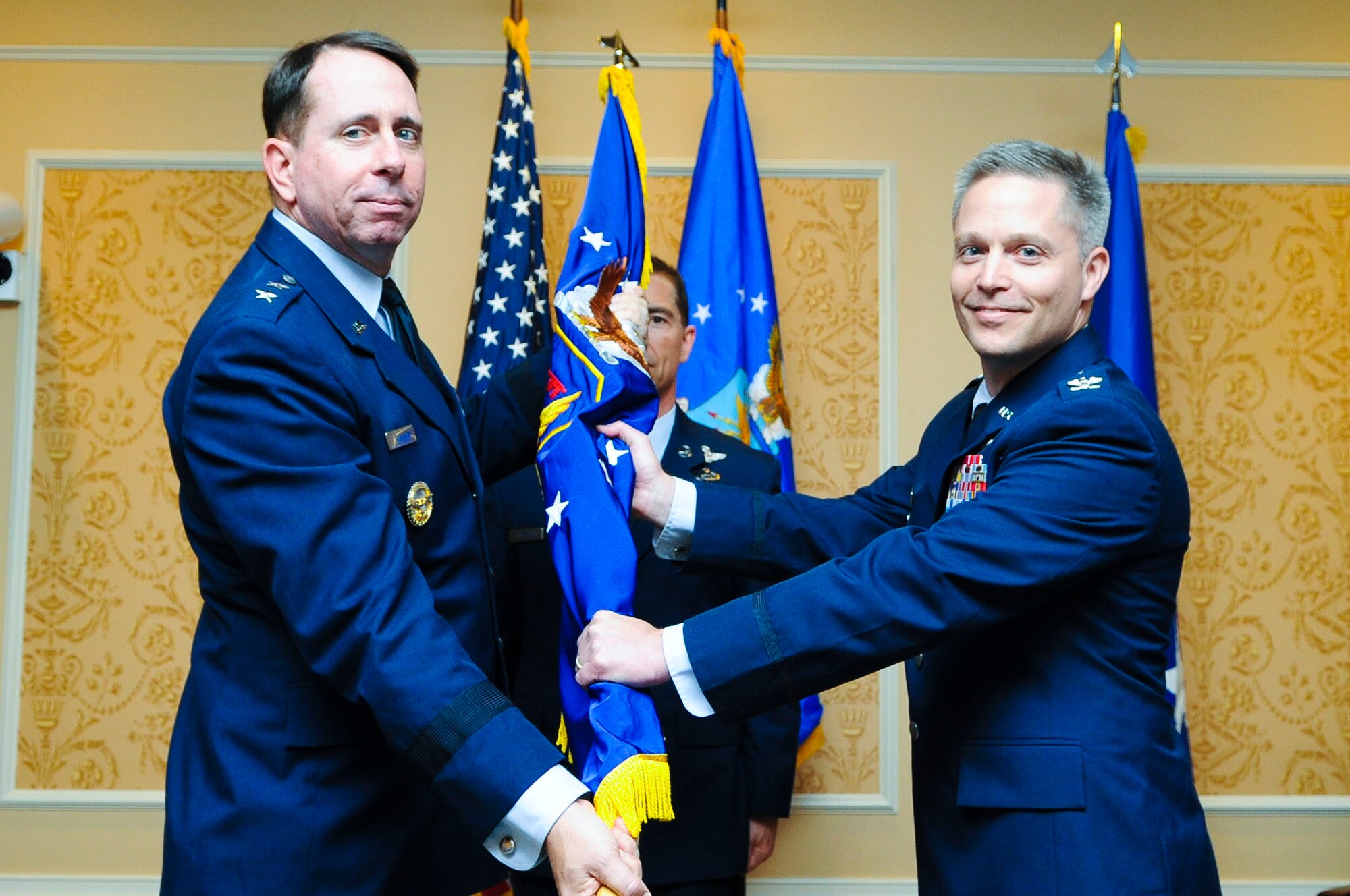 United States Air Force Maj. Gen. John Shanahan, Air Force Intelligence, Surveillance and Reconnaissance Agency commanding general, passes the 480th ISR Wing colors to Col. Timothy Haugh, 480th ISR Wing commander, during a change of command ceremony at Langley Air Force Base, Va., June 6, 2014. Haugh said he hopes to learn from the 480th ISR Wing’s professionalism and drive and provide the best cyberspace, imagery and other intelligence products to every American and coalition Service member. (U.S. Air Force photo by Senior Airman Austin Harvill/Released) 