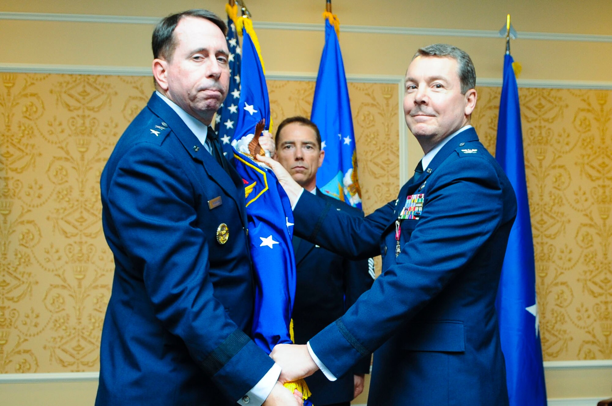 United States Air Force Col. Jeffrey Kruse, former 480th Intelligence, Surveillance and Reconnaissance Wing commander, passes the 480th ISR Wing colors to Maj. Gen. John Shanahan, Air Force ISR Agency commanding general, during a change of command ceremony at Langley Air Force Base, Va., June 6, 2014. Col. Kruse spent two years as the wing commander. (U.S. Air Force photo by Senior Airman Austin Harvill/Released) 