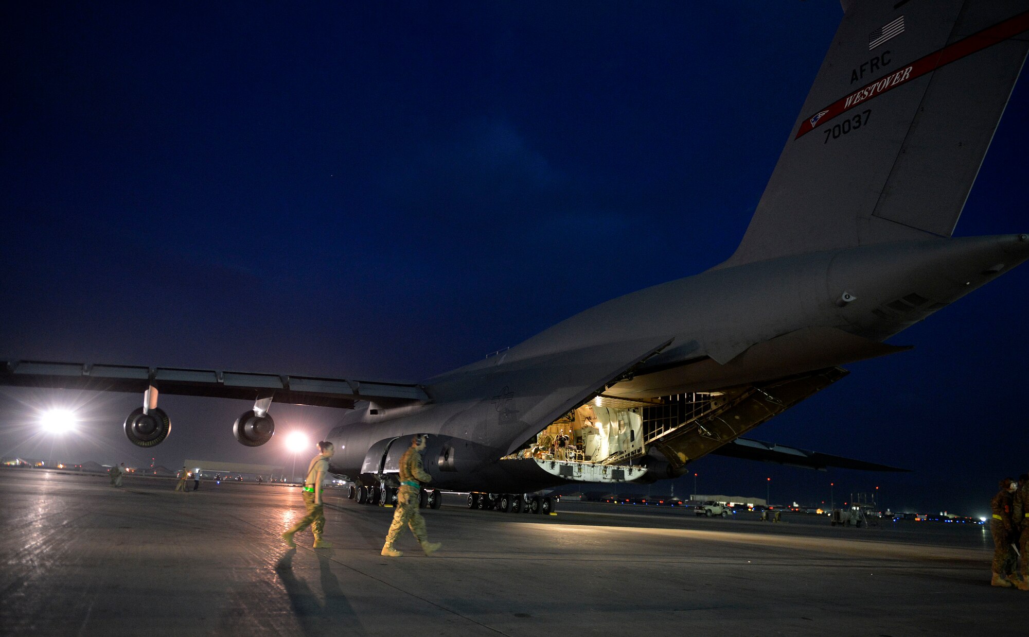 U.S. Air Force Airmen from the 455th Expeditionary Aerial Port Squadron walk toward a C-5 Galaxy aircraft at Bagram Airfield, Afghanistan May 26, 2014.  Aerial porters here sustain cargo and passenger movement in the busiest aerial port in the Department of Defense. (U.S. Air Force photo by Staff Sgt. Evelyn Chavez/Released)