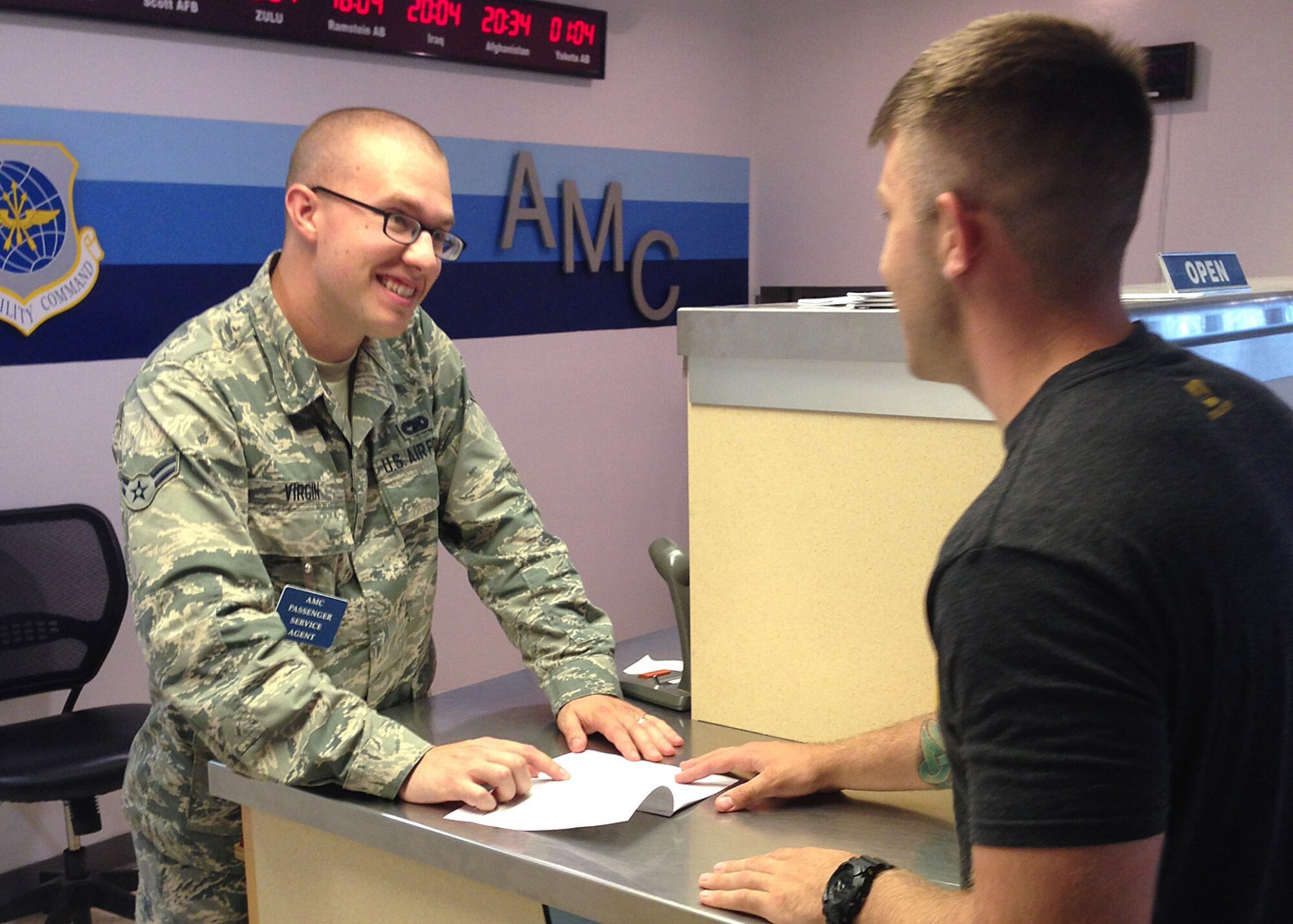 Airman 1st Class John Virgin, a passenger service agent from the 3rd Aerial Port Squadron, explains Air Mobility Command's Space-A travel options available at Pope Army Airfield to a customer. (U.S. Air Force photo/1st Lt. Henry Kehs) 