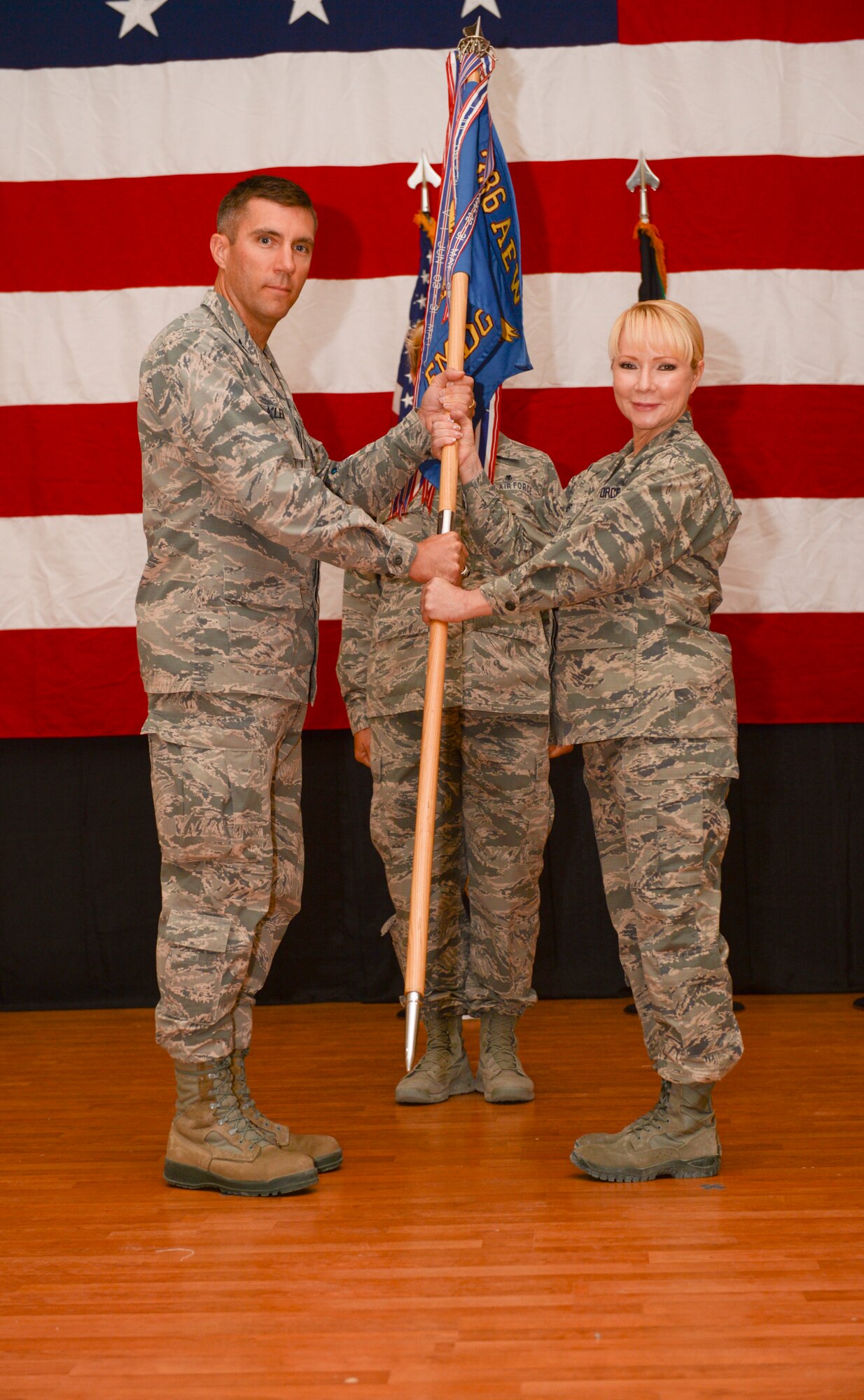 Col. Susan Davis, 386th Expeditionary Medical Group incoming commander, accepts the 386th EMDG guidon from Col. John Klein, 386th Air Expeditionary Wing commander, during a change of command ceremony held June 8, 2014 at The Rock. Col. Jeanine Ryder relinquished command of the 386th EMDG to Davis who deployed from the 59th Medical Wing, Joint Base San Antonio-Lackland, Texas. (U.S. Air Force photo by Staff Sgt. Jeremy Bowcock)
