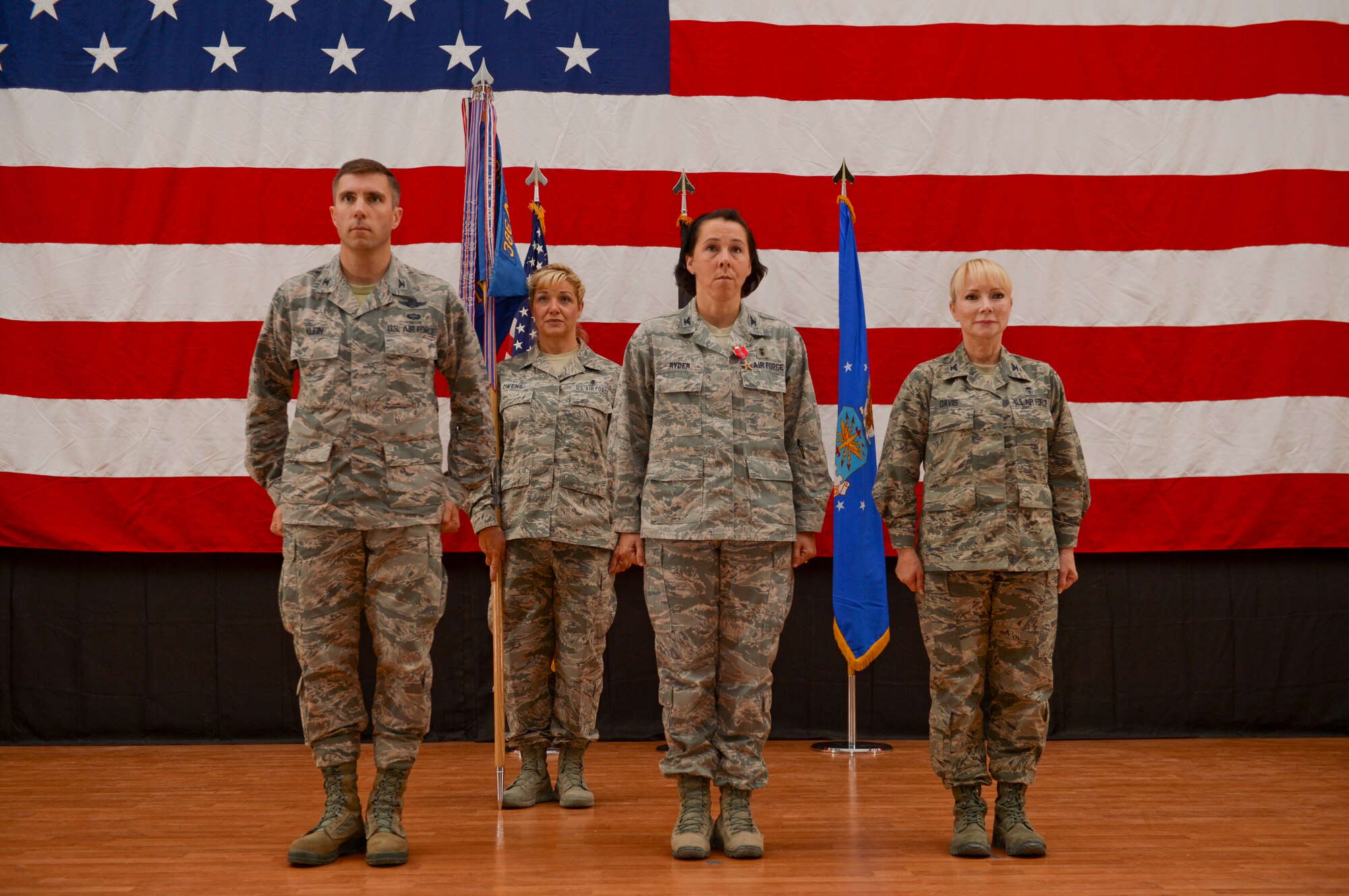Col. John Klein (left), 386th Air Expeditionary Wing commander, Col. Jeannine Ryder (middle), 386th Expeditionary Medical Group outgoing commander and Col. Susan Davis (right), incoming 386th EMDG commander stand at attention during a change of command ceremony held June 8, 2014 at The Rock. The 386th EMDG, supports the wing mission by ensuring a healthy and fit force and providing combat medical support, dental and force health protection for the Department of Defense and U.S. Forces throughout Southwest Asia. (U.S. Air Force photo by Staff Sgt. Jeremy Bowcock)