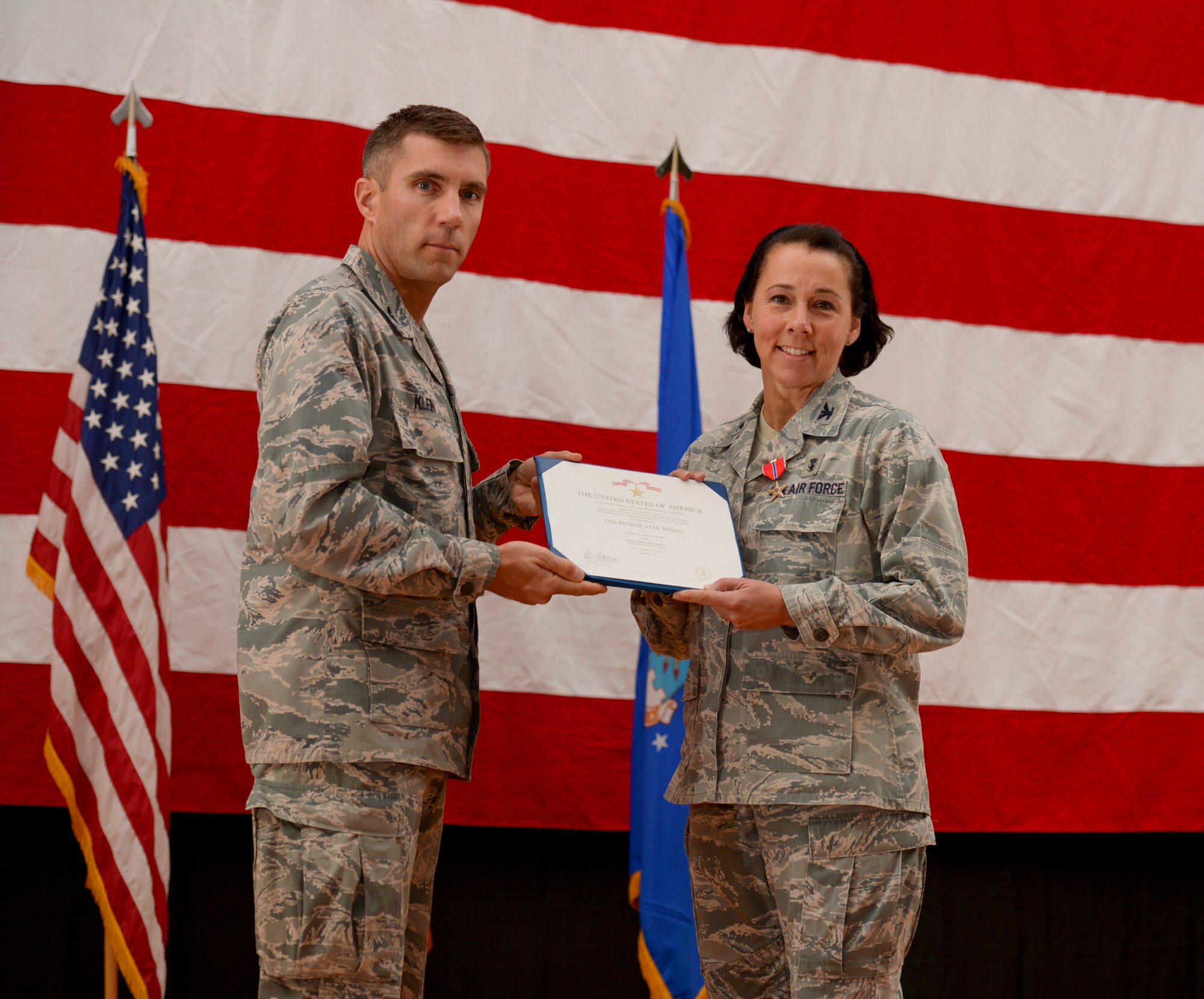 Col. Jeannine Ryder, 386th Expeditionary Medical Group commander, is presented with a Bronze Star medal by Col. John Klein, 386th Air Expeditionary Wing commander, June 8, 2014 during a change of command ceremony held at The Rock. Ryder was awarded the medal just before relinquishing command of the 386th EMDG to Col. Susan Davis. (U.S. Air Force photo by Staff Sgt. Jeremy Bowcock)